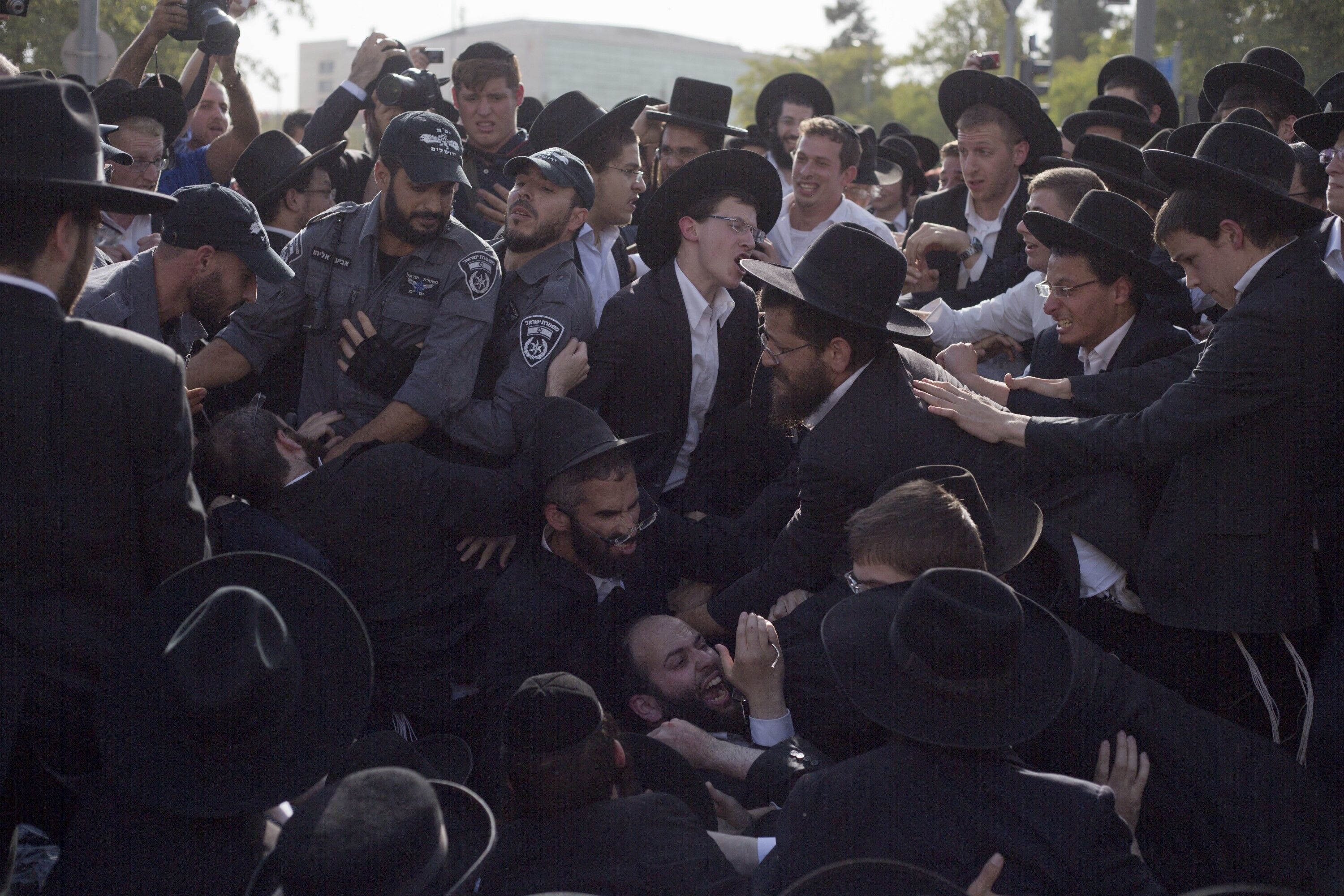 Israeli Police scuffle with ultra-Orthodox Jews as they block a main road during a protest against Israeli army conscription, in Jerusalem, Thursday, Oct. 19, 2017. Police say they have arrested 40 people in protests by a fringe group within the ultra-Orthodox community.(AP Photo/Ariel Schalit)