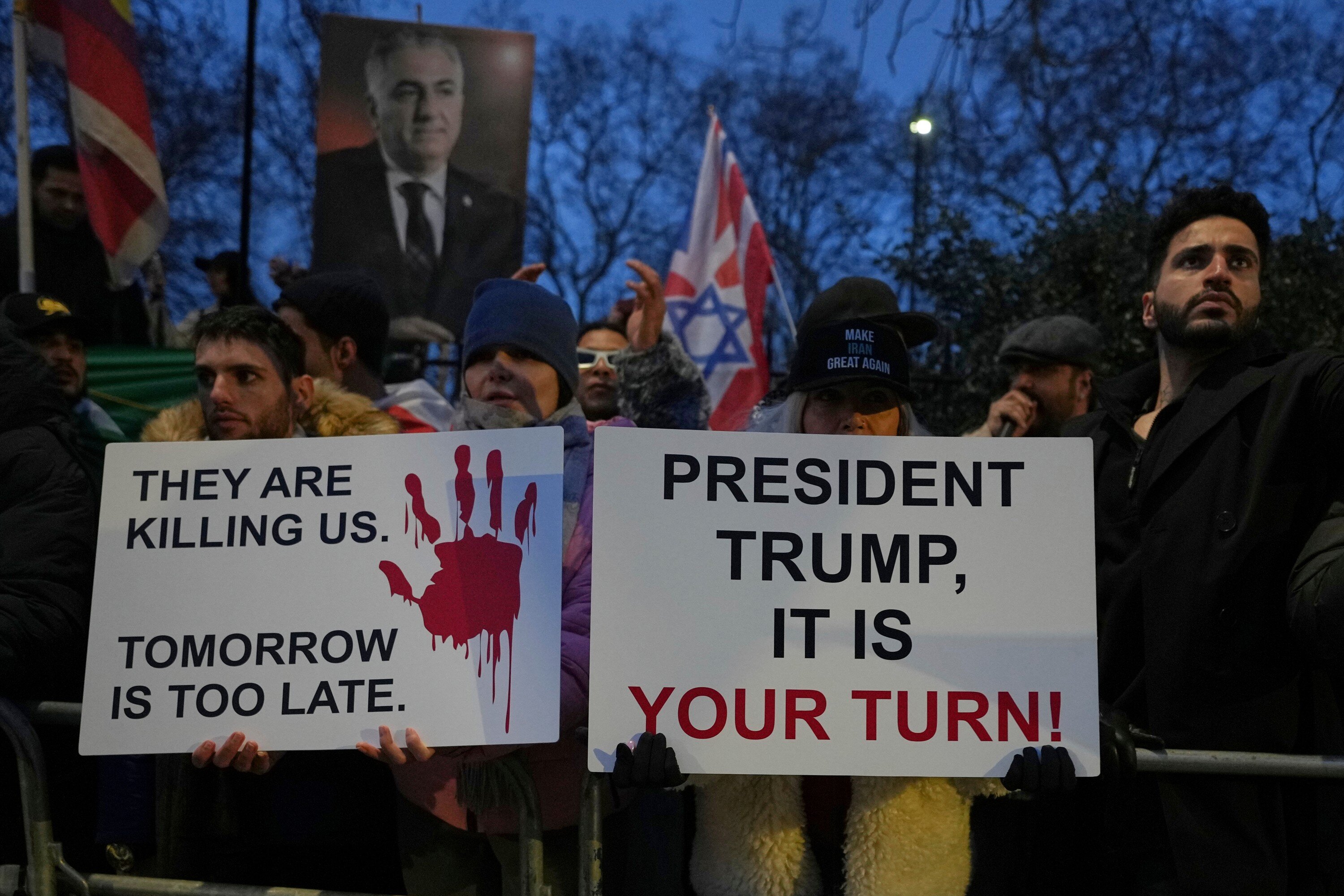 Protesters hold up placards and flags as they demonstrate outside the Iranian Embassy in London, Monday, Jan. 12, 2026. (AP Photo/Alastair Grant)