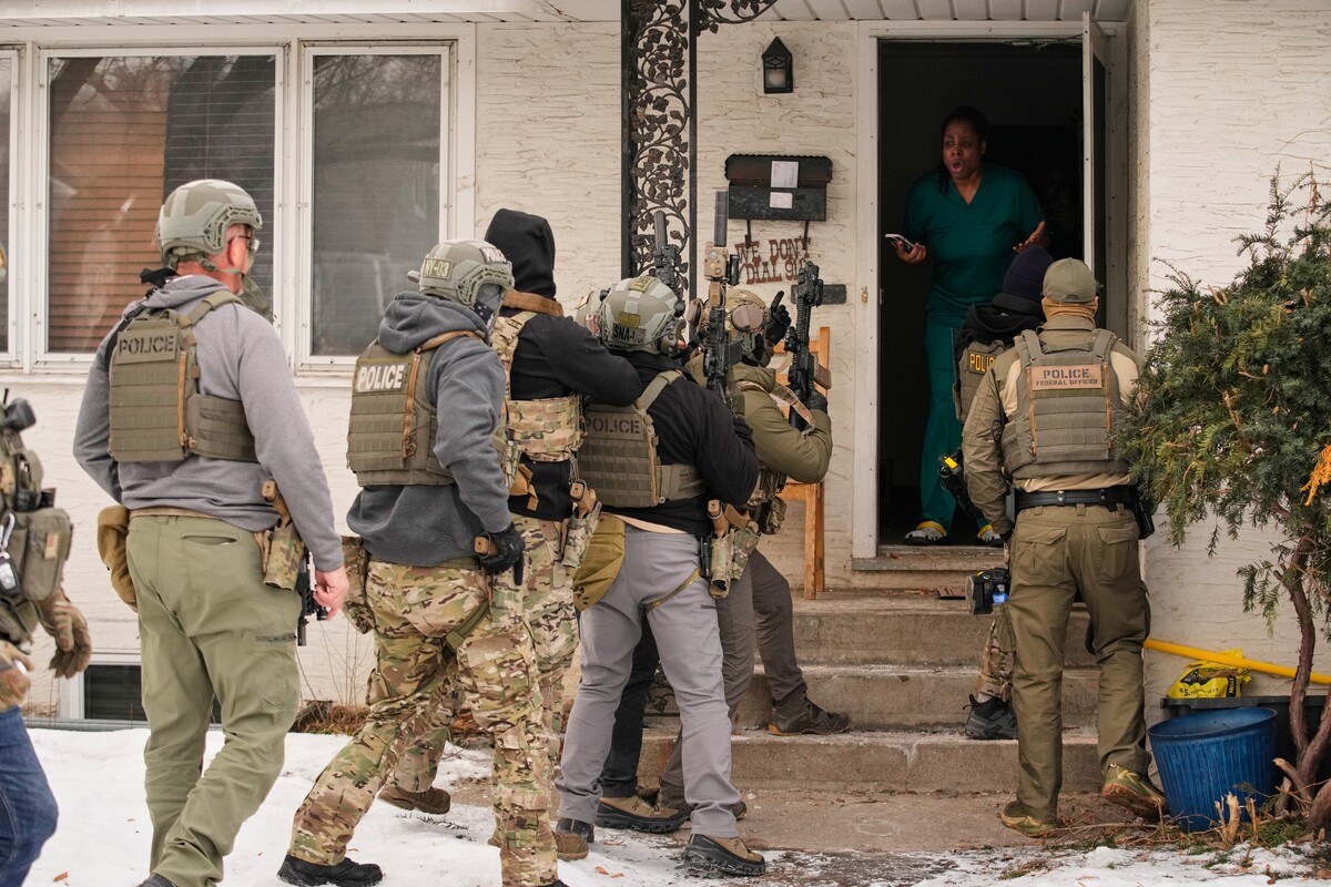 FILE - A family member reacts after a federal immigration officer used a battering ram to break down a door before making an arrest Sunday, Jan. 11, 2026, in Minneapolis. (AP Photo/John Locher)