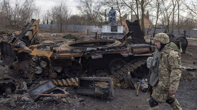 Ukrajinski vojnik pored uništenog ruskog tenka u naselju Lukjavnika u blizini Kijeva, 27. ožujka 2022. (izvor: REUTERS/Marko Djurica/Guliver Image)