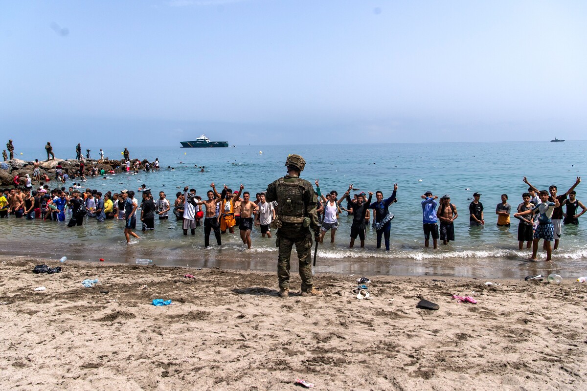 Španjolski vojnik i migranti na plaži u Ceuti, 31. srpnja 2026.