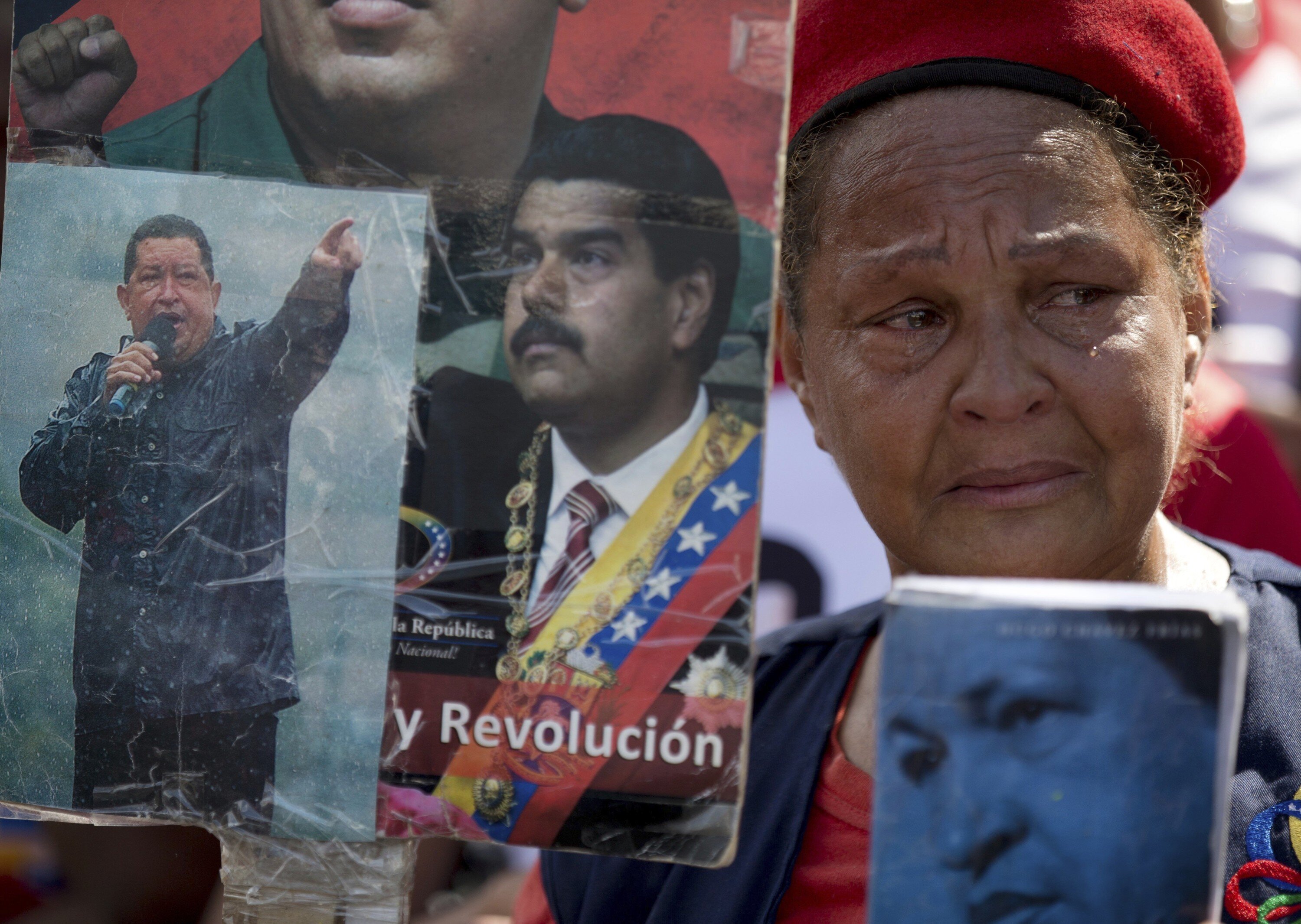 FILE - In this March 15, 2018 file photo, a supporter of Venezuela's late President Hugo Chavez and current President Nicolas Maduro attends a rally marking the fifth anniversary of Chavez's death, in Caracas, Venezuela. A Harvard-trained conflict resolution expert is flying to Caracas to attempt the seemingly impossible: jumpstarting political dialogue in deeply polarized Venezuela. (AP Photo/Fernando Llano)