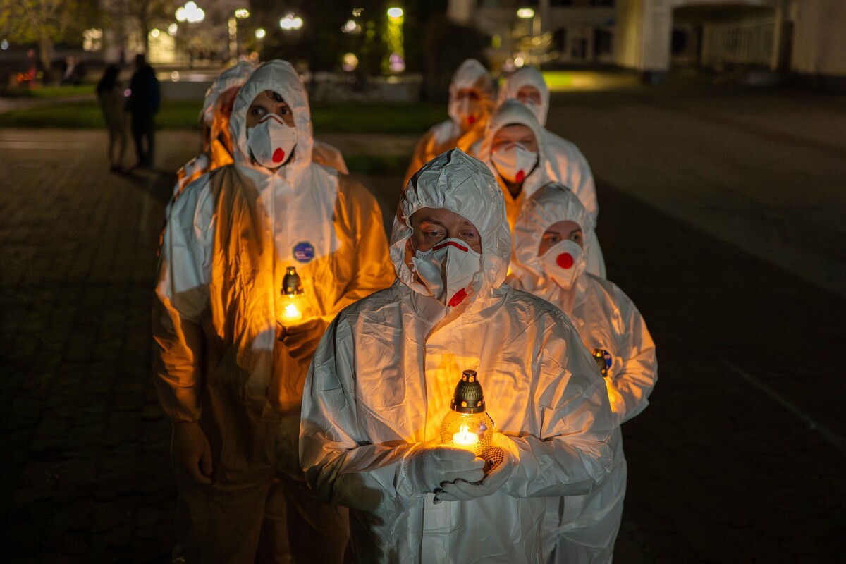 People dressed in white protective suits carry candles during a memorial service dedicated to firefighters and workers who died after the 1986 Chornobyl (Chernobyl) nuclear disaster, ahead of its 40th anniversary in Slavutych, Ukraine, Saturday, April 25, 2026. Chornobyl is the Ukrainian name for the city.  (AP Photo/Dan Bashakov)
