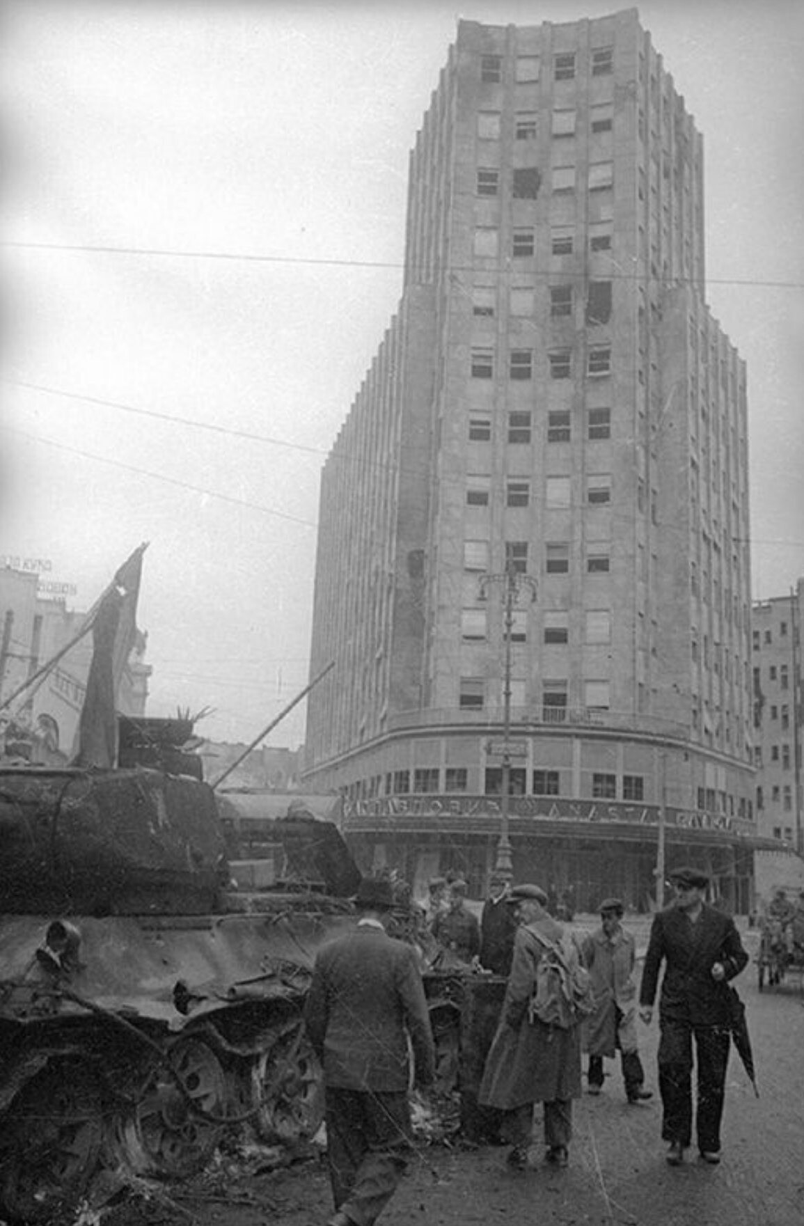 A burning Soviet tank in front of the Albanija Palace