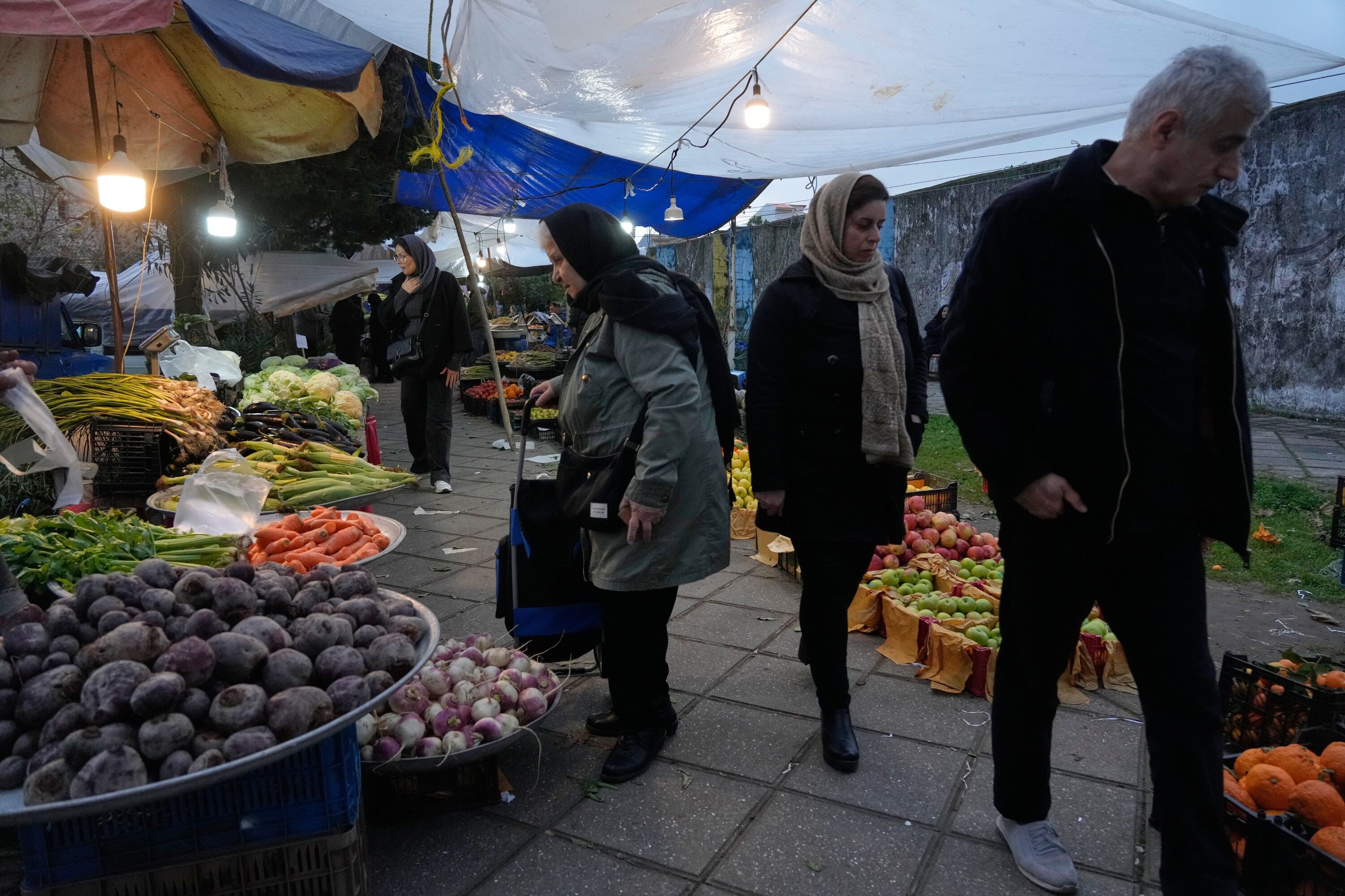People conduct businesses at a traditional street market in the port city of Bandar Anzali in the southern coast of the Caspian Sea, Iran, Thursday, Dec. 25, 2025. (AP Photo/Vahid Salemi)