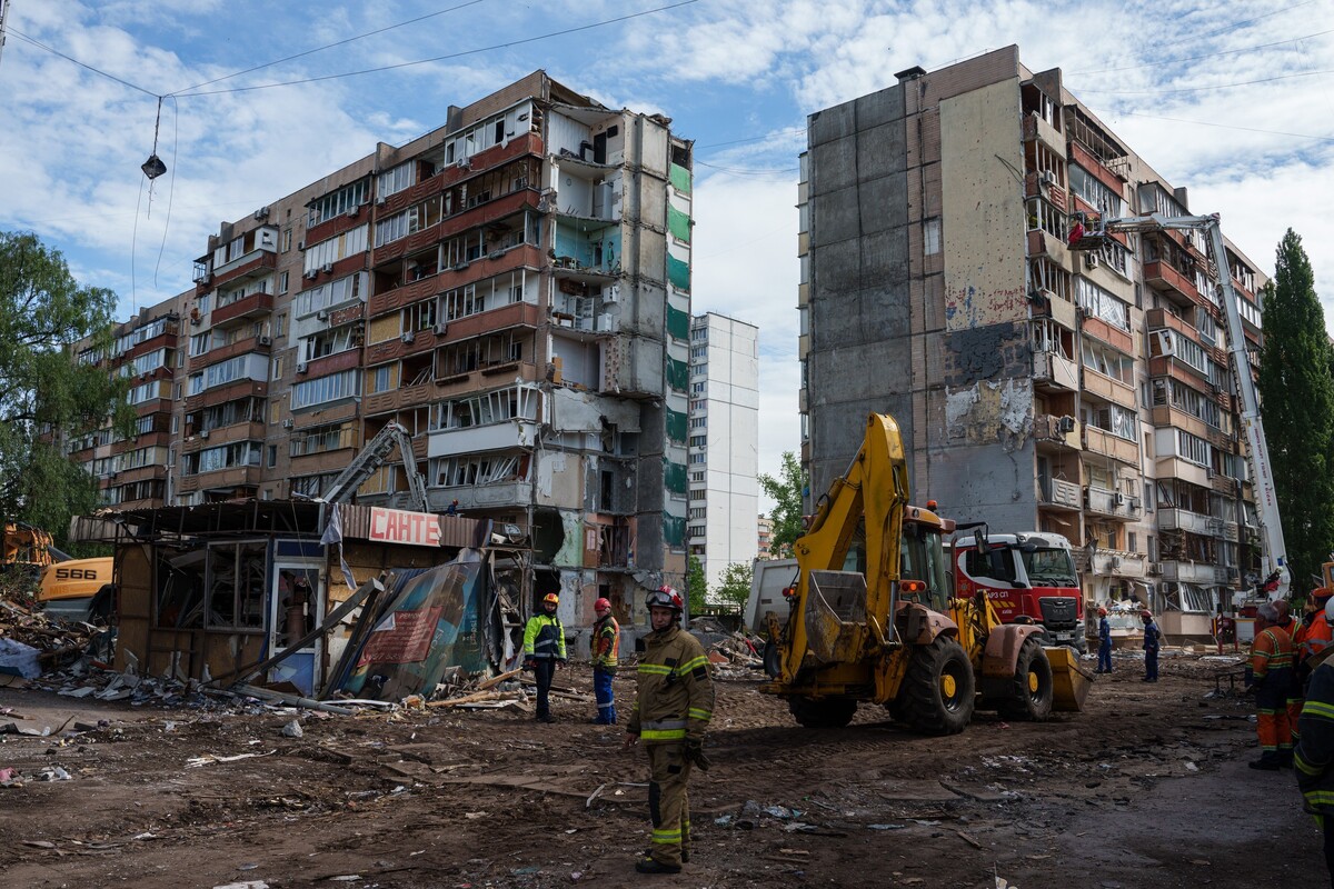 Rescue workers stand in the yard of an apartment building heavily damaged after a Russian strike on residential neighbourhood in Kyiv, Ukraine, on Friday, May 15, 2026. (AP Photo/Evgeniy Maloletka)