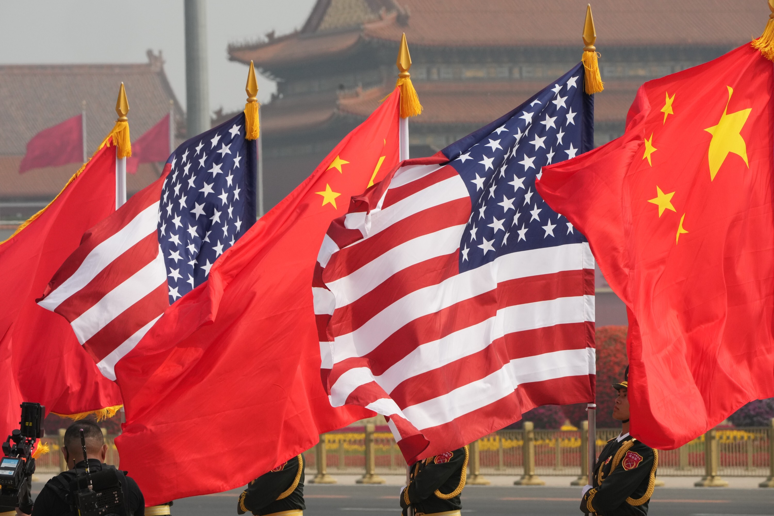 Members of the military honor guard hold American and Chinese flags before President Donald Trump is greeted by Chinese President Xi Jinping at a welcome ceremony at the Great Hall of the People, Thursday, May 14, 2026, in Beijing. (AP Photo/Mark Schiefelbein)