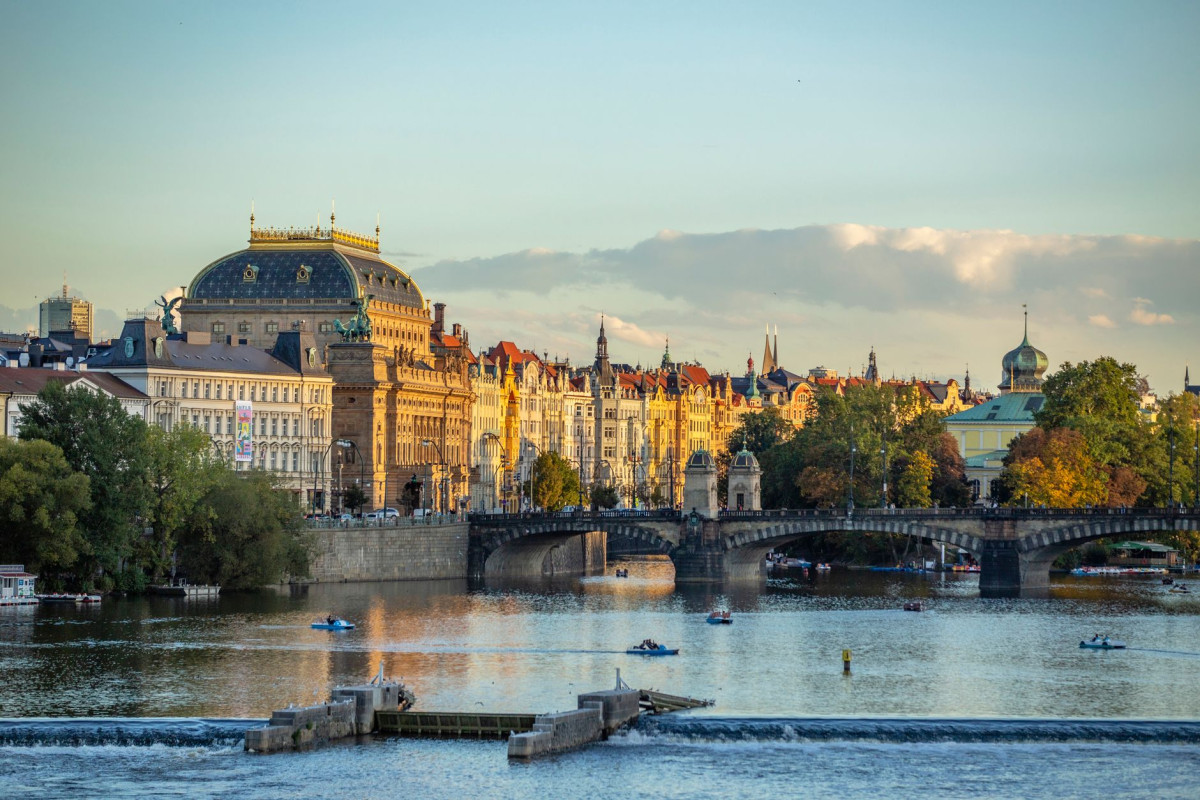 Beautiful view of historic buildings by the Vltava River in Prague at sunset.
