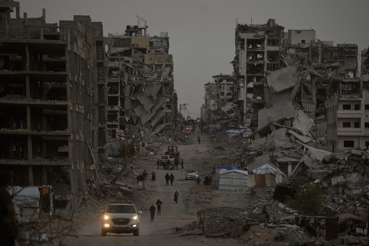 Palestinians walk through the destruction in the Al-Karama neighborhood of Gaza City Sunday, Nov. 30, 2025. (AP Photo/Jehad Alshrafi)