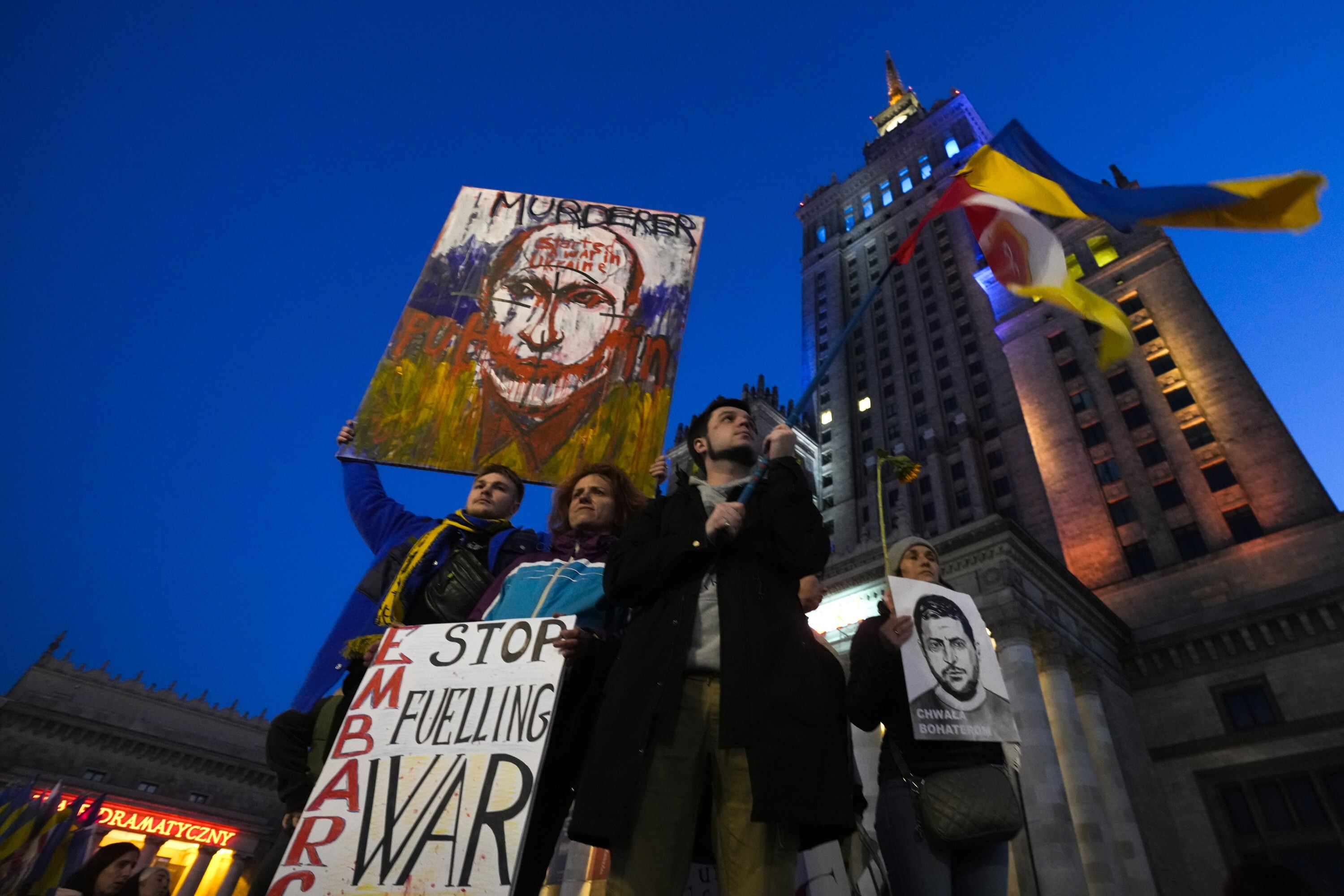 Fridays For Future climate activist holds portraits of Russian President Vladimir Putin, left, and Ukrainian President Volodymyr Zelenskyy during a protest demanding an energy embargo to Russia and the stop of the war in Ukraine, in Warsaw, Poland, Friday, April 22, 2022. The march started near the Embassy of Germany, as Berlin has been developing import of Russia's energy sources and has been reluctant to support Ukraine's struggle with weapons. (AP Photo/Czarek Sokolowski)