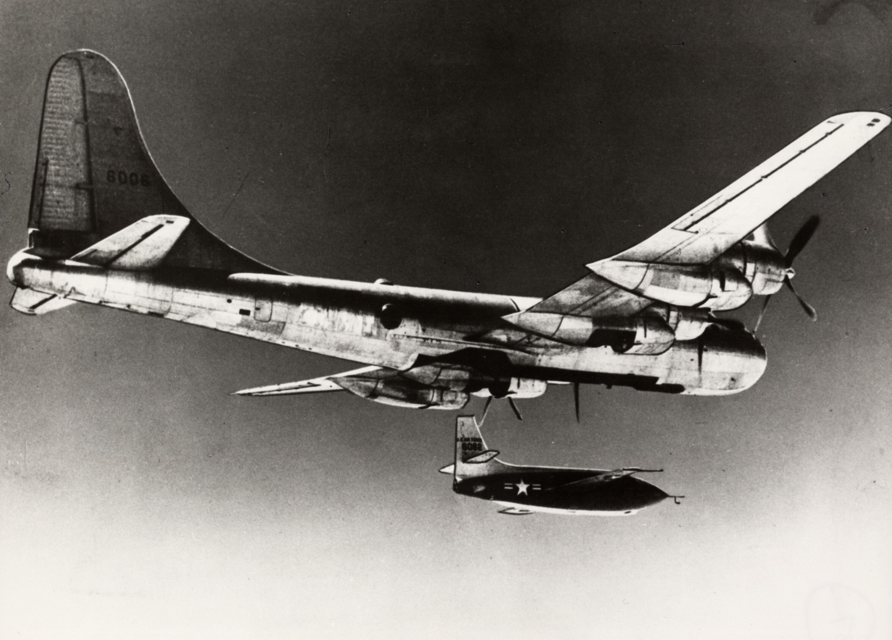 One-half right rear view from below showing Bell X-1 "Glamorous Glennis" (s/n 46-062) in flight moments after release from Boeing EB-50A Superfortress (s/n 46-0006; c/n 15726) mothership.
