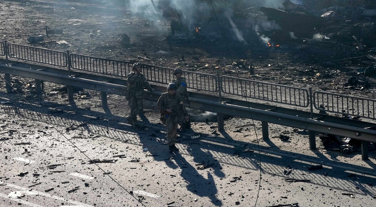 Ukrajinski vojnici na ulici u Kijevu, u pozadini se vide ostaci zapaljenog vojnog kamiona - 26.2.2022. (izvor: AP Photo/Efrem Lukatsky/Guliver Image)
