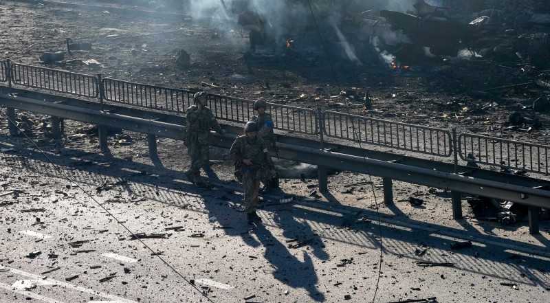 Ukrajinski vojnici na ulici u Kijevu, u pozadini se vide ostaci zapaljenog vojnog kamiona - 26.2.2022. (izvor: AP Photo/Efrem Lukatsky/Guliver Image)