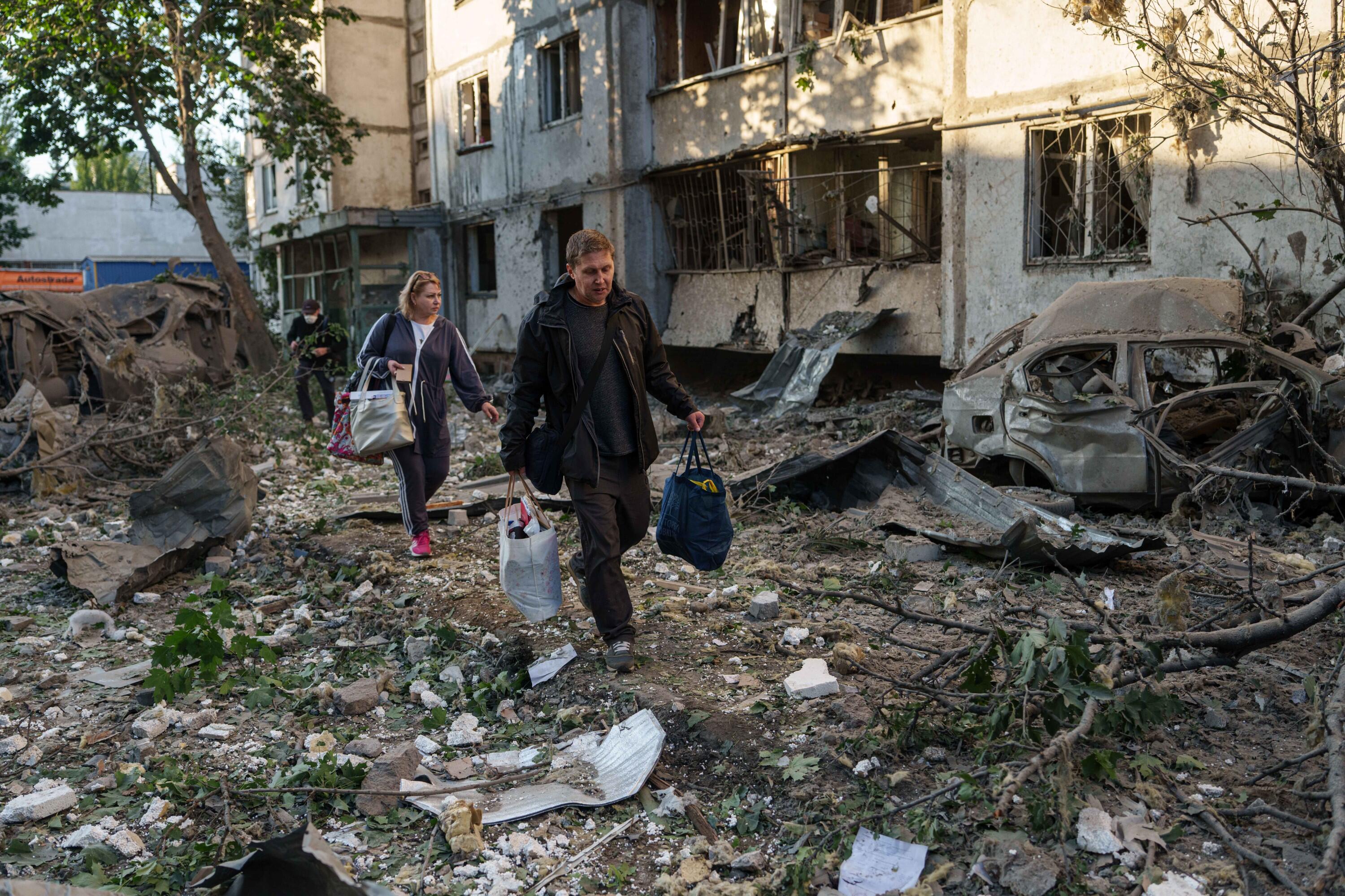 People carry their belongings from a residential building that was damaged following a Russian strike on Kyiv, Ukraine, on Tuesday, June 2, 2026. (AP Photo/Evgeniy Maloletka)