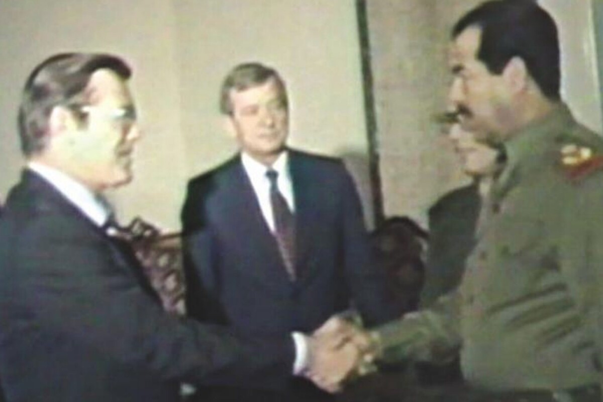 Donald Rumsfeld, who would later serve as U.S. defense secretary and become an architect of the Iraq War, greets Saddam Hussein in December 1983.