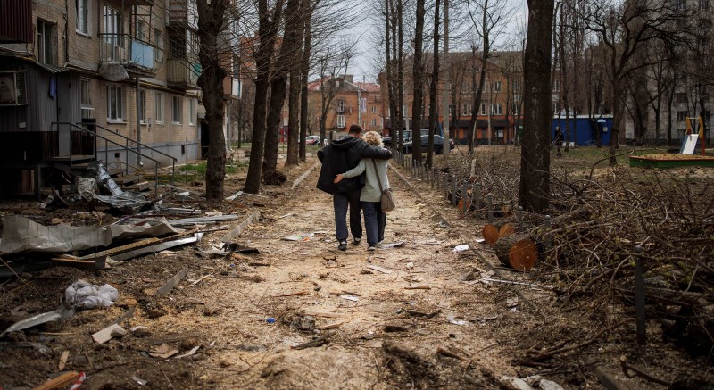 Par prolazi pokraj pogođene zgrade u Harkovu, 10. travnja 2022. (izvor: REUTERS/Alkis Konstantinidis/Guliver Image)