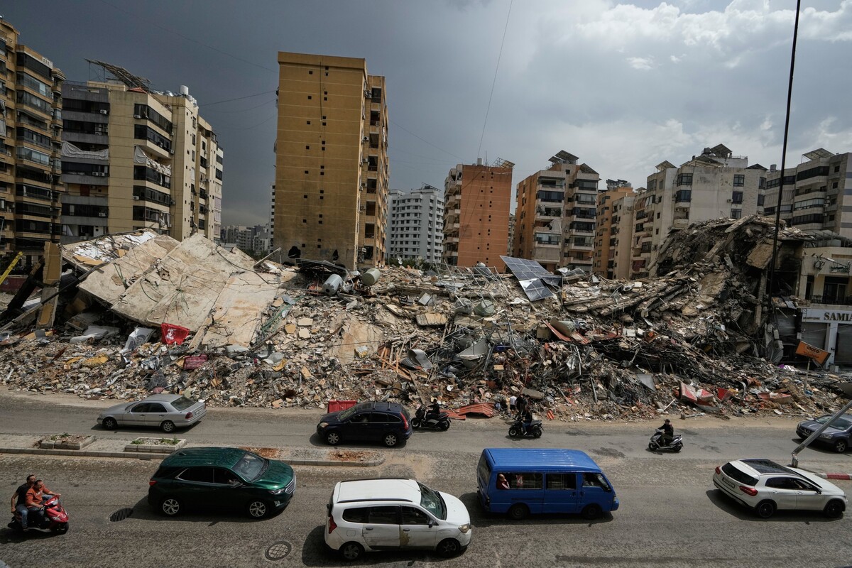Residents drive past the rubble of destroyed buildings in Dahiyeh, Beirut's southern suburbs, Lebanon, Friday, April 17, 2026, following a ceasefire between Israel and Hezbollah. (AP Photo/Bilal Hussein)