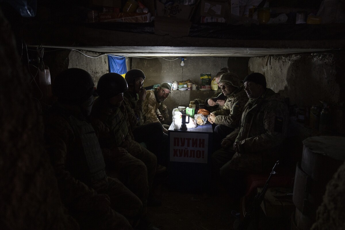 Ukrainian soldiers eat inside an army trench on the outskirts of Mykolaiv, Ukraine, Saturday, March 26, 2022.(AP Photo/Petros Giannakouris)
