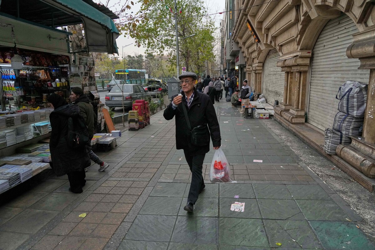 A man walks on a sidewalk in downtown Tehran, Iran, Thursday, Jan. 15, 2026. (AP Photo/Vahid Salemi)