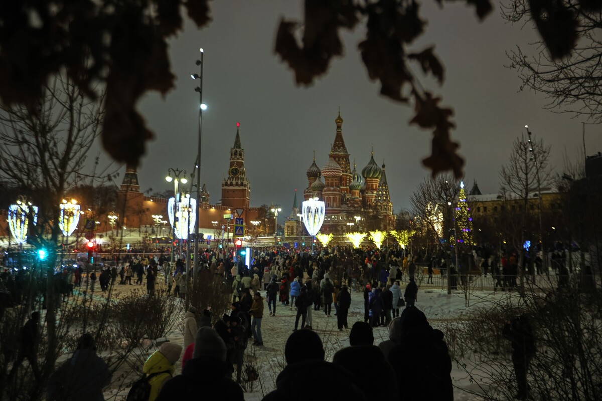 People celebrate the New Year outside Red Square with the Spasskaya Tower and the St. Basil's Cathedral, in the background, in Moscow, on Wednesday, Dec. 31, 2025.(AP Photo)